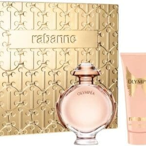 Rabanne Olympea gift set displayed in front of a gold embossed box. The set includes the round Olympea perfume bottle with rose-gold details, a matching pink body lotion with gold wings, and a slim travel spray.